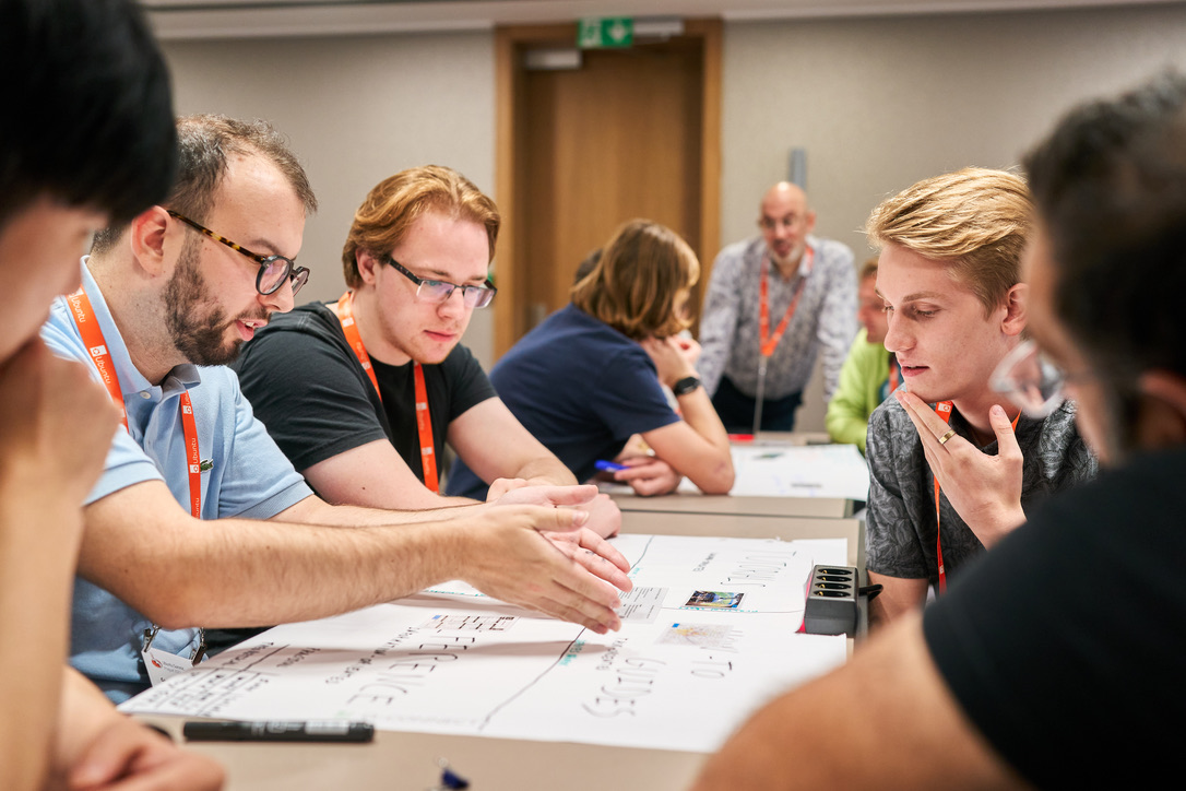 Workshop participants sitting around a table analyse user needs in documentation situations